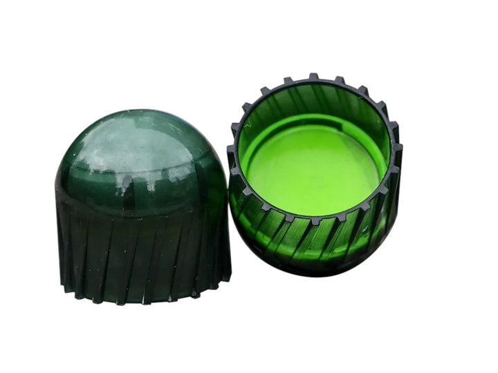 A green translucent plastic cap or cover shown disassembled into two pieces on a plain white background.
