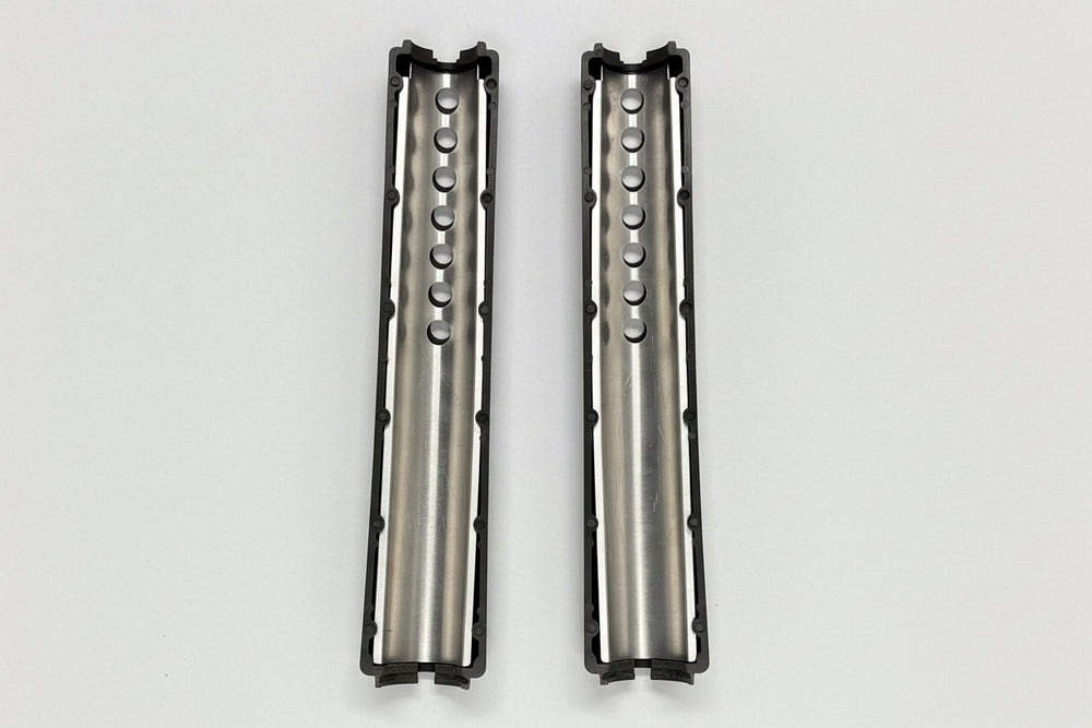 Two metallic cylindrical objects with textured surfaces on a light gray background