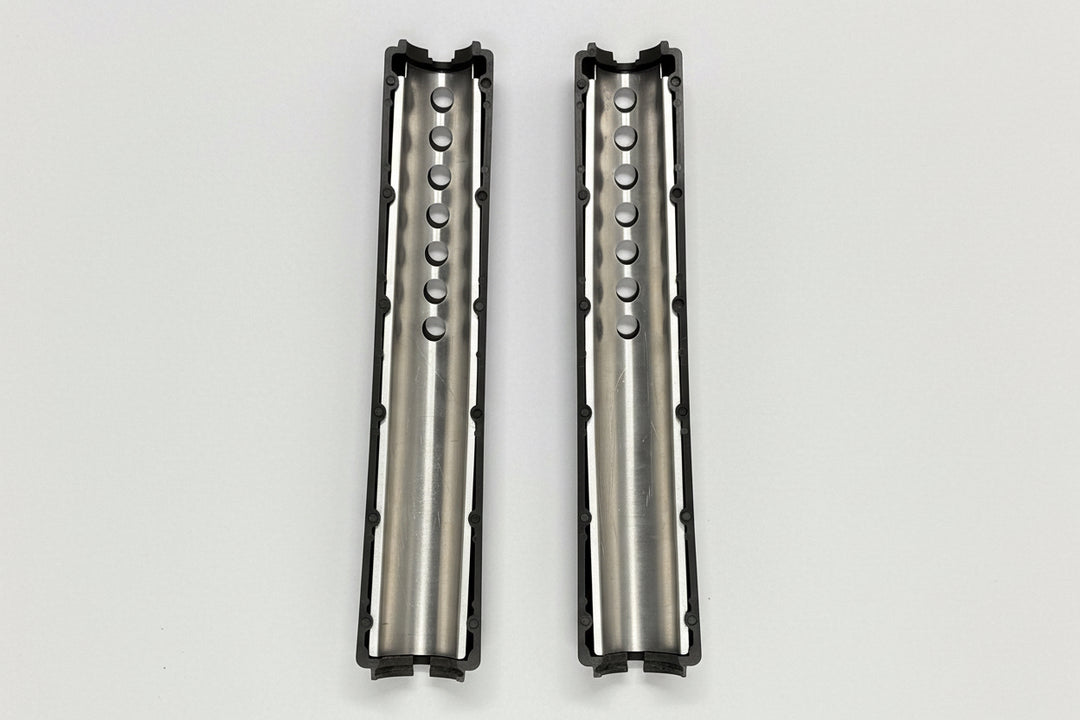 Two metallic cylindrical objects with textured surfaces on a light gray background